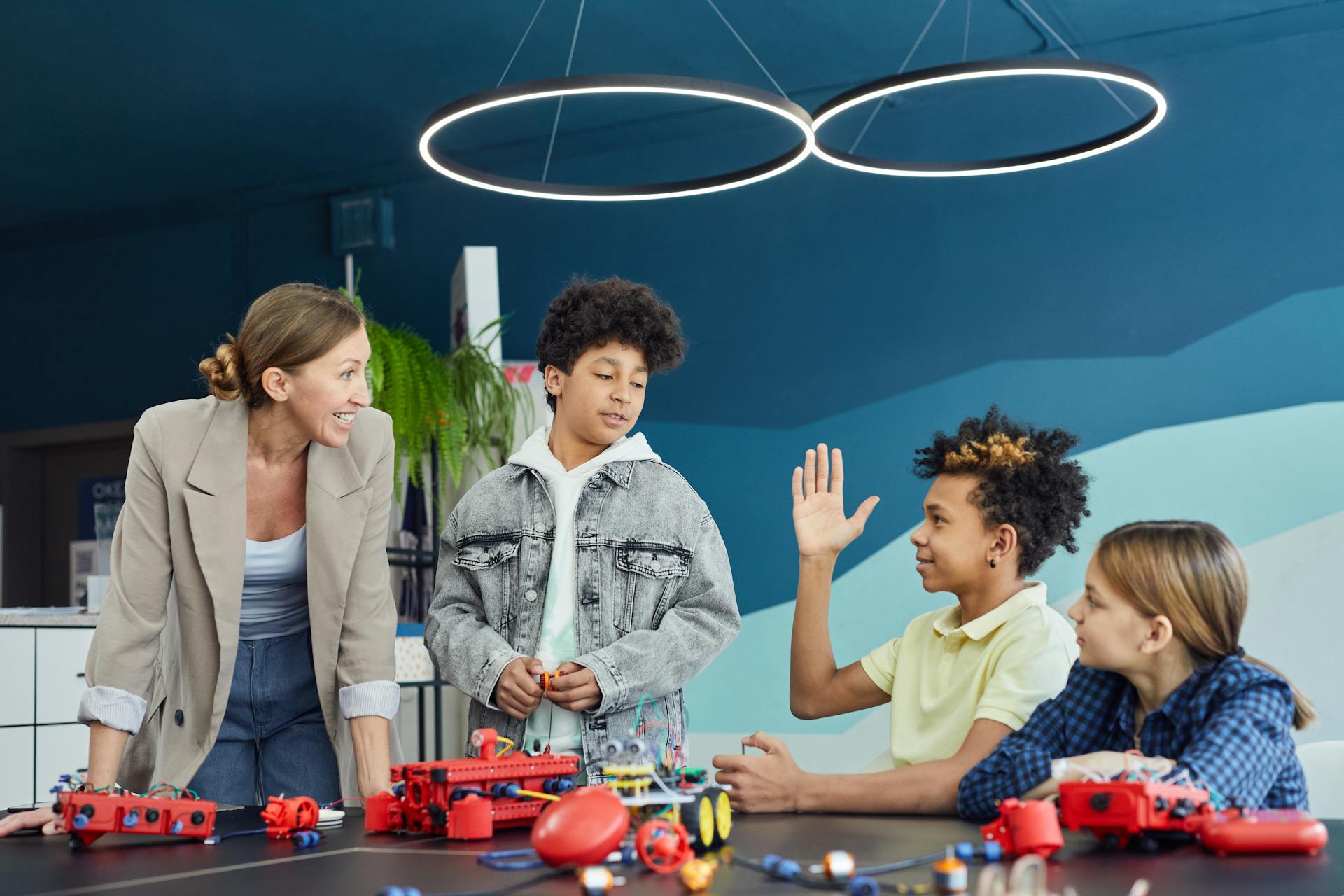 Profesora sonriente con niños aprendiendo robótica y tecnología educativa